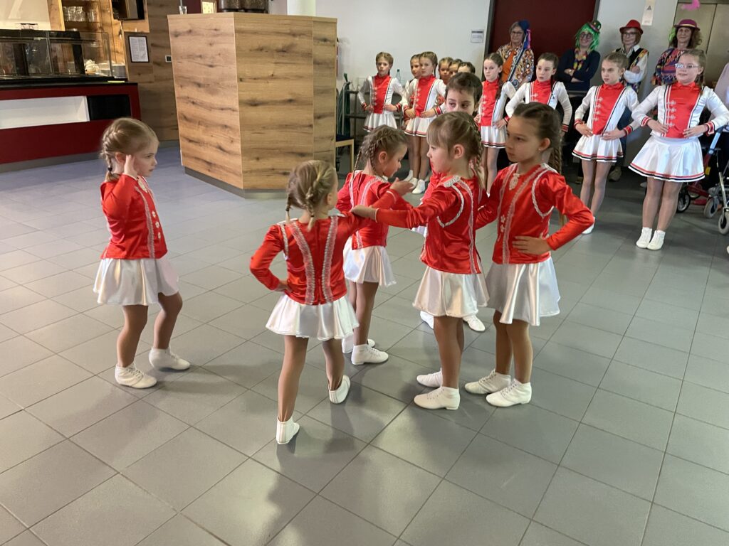 Eine Gruppe junger Mädchen in roten und weißen Kleidern.